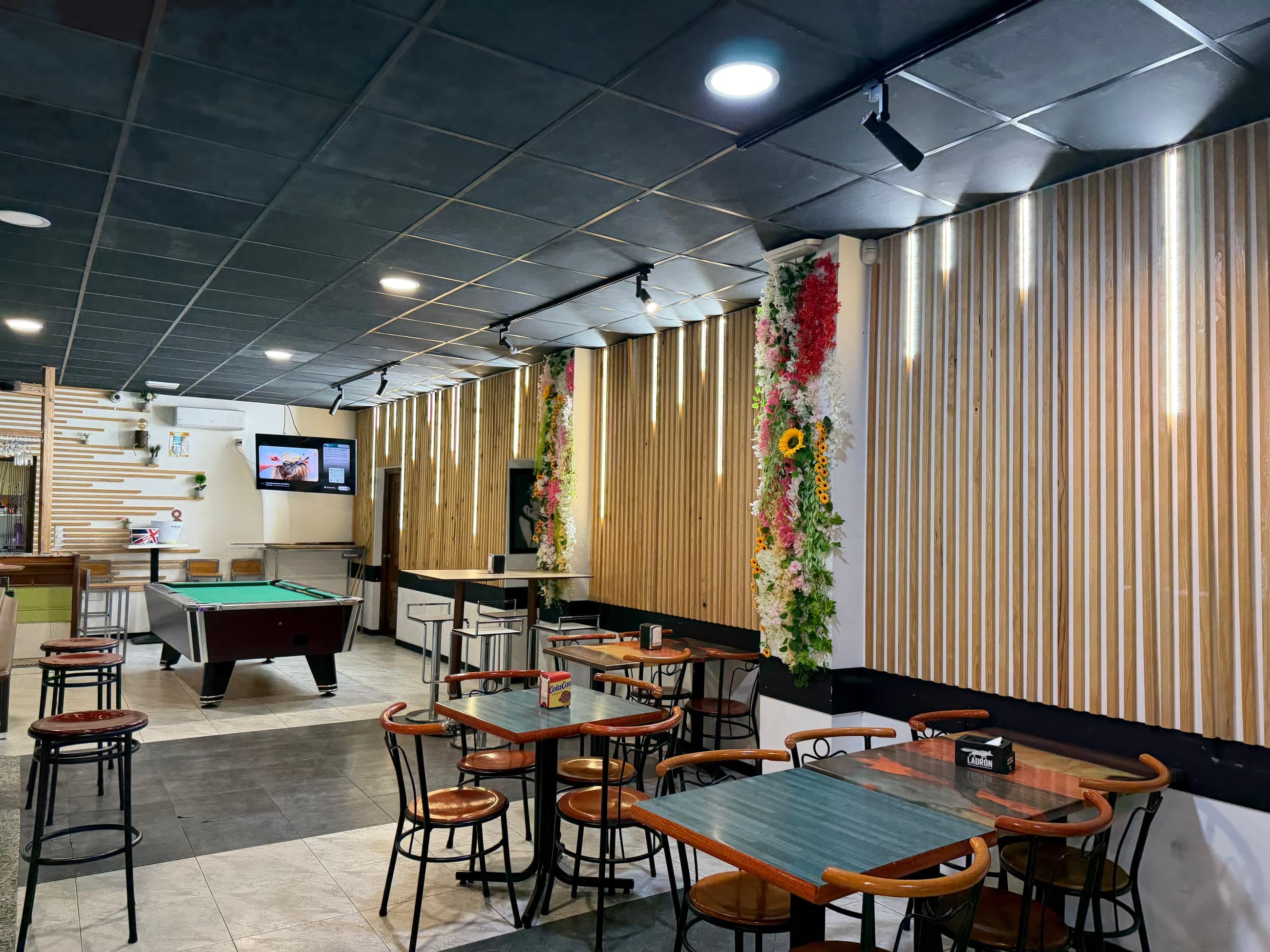 Salón de La Marea con mesas, madera y decoración floral