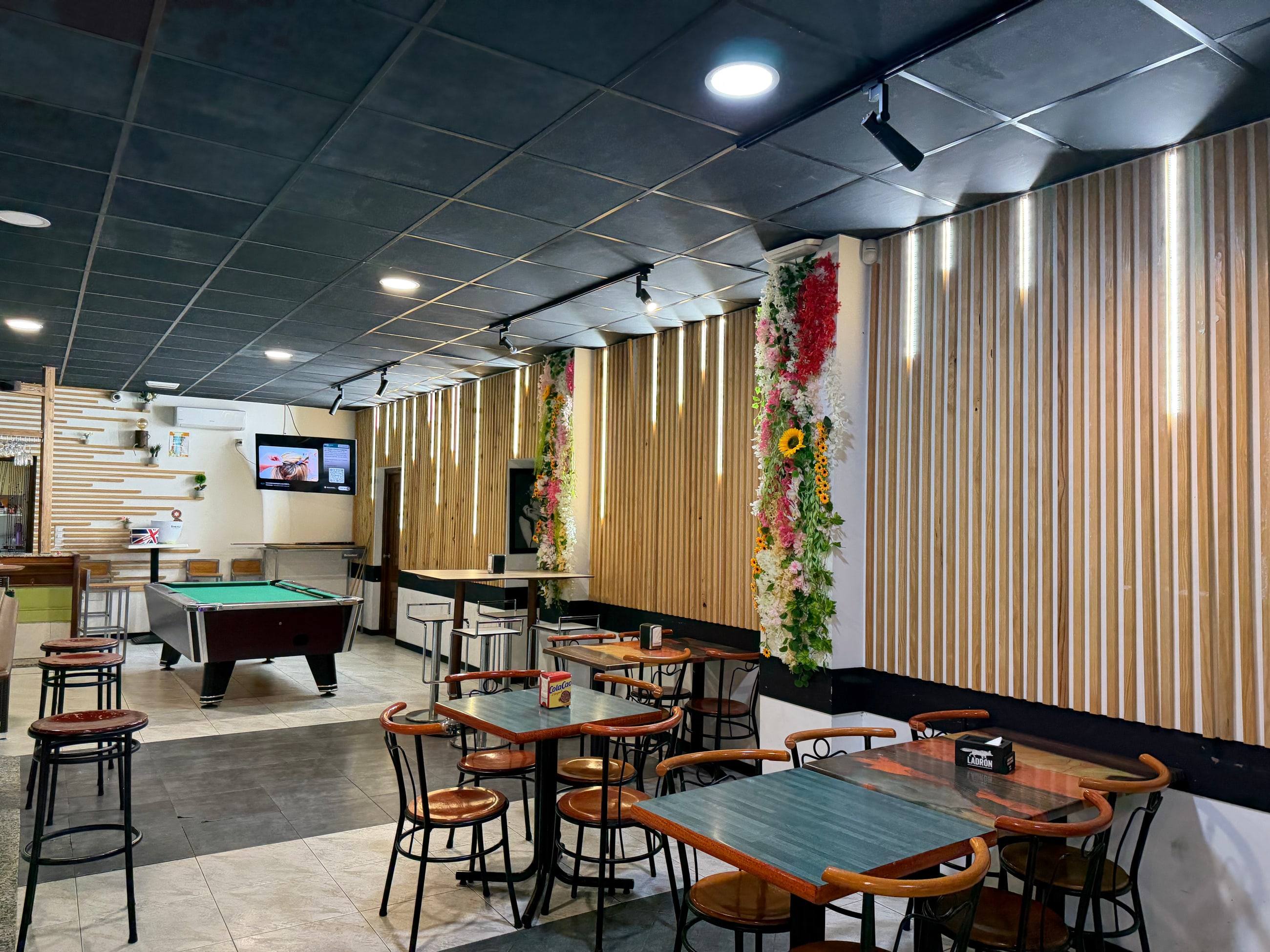 Salón de La Marea con mesas, madera y decoración floral